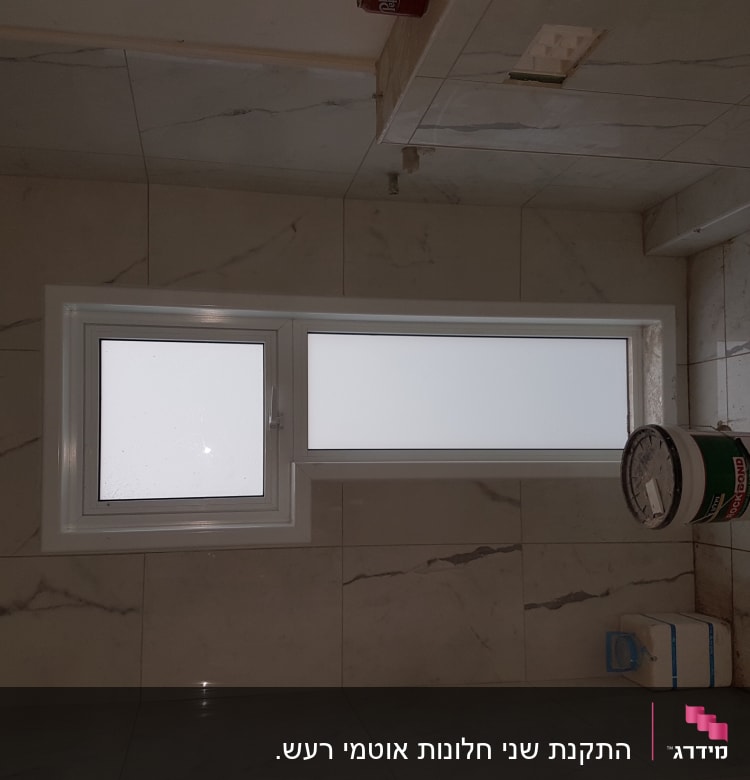 חלון אלומיניום עם זכוכית חלבית על קיר שיש